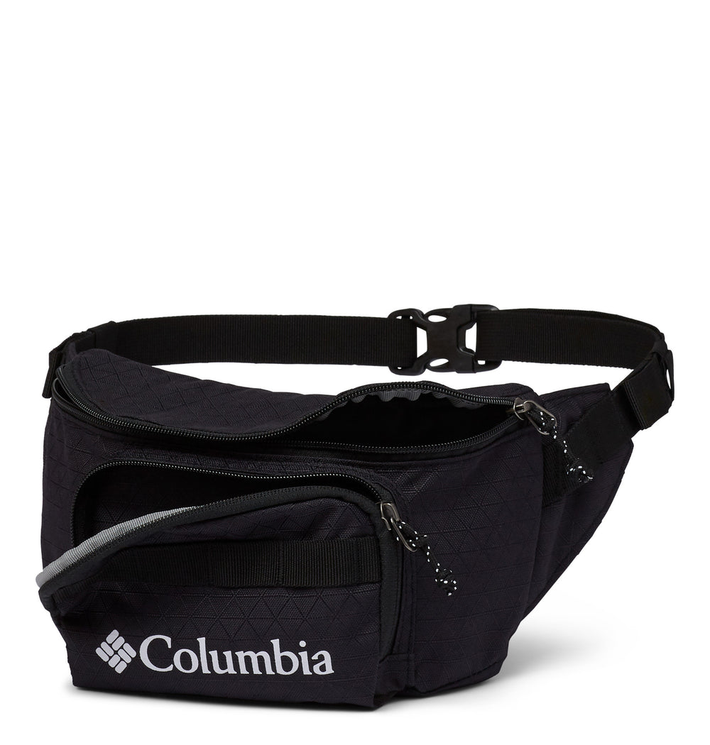 Angle view of a black fanny pack called Zig Zag designed by Columbia showing its belt strap, open zipper compartments, and logo printed in the front.