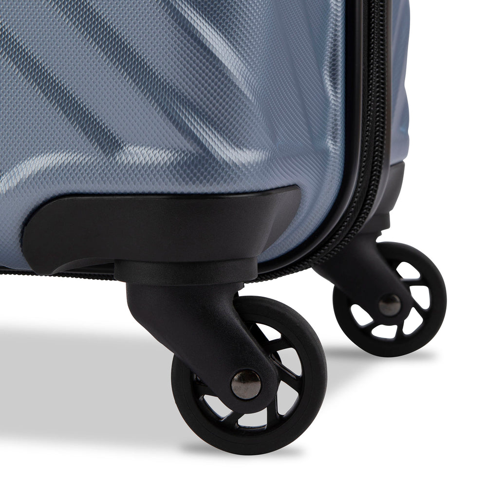 Close up view of a luggage called MOD designed by Swiss Gear sold at Bentley, showcasing 2 of its 4 spinner wheels.