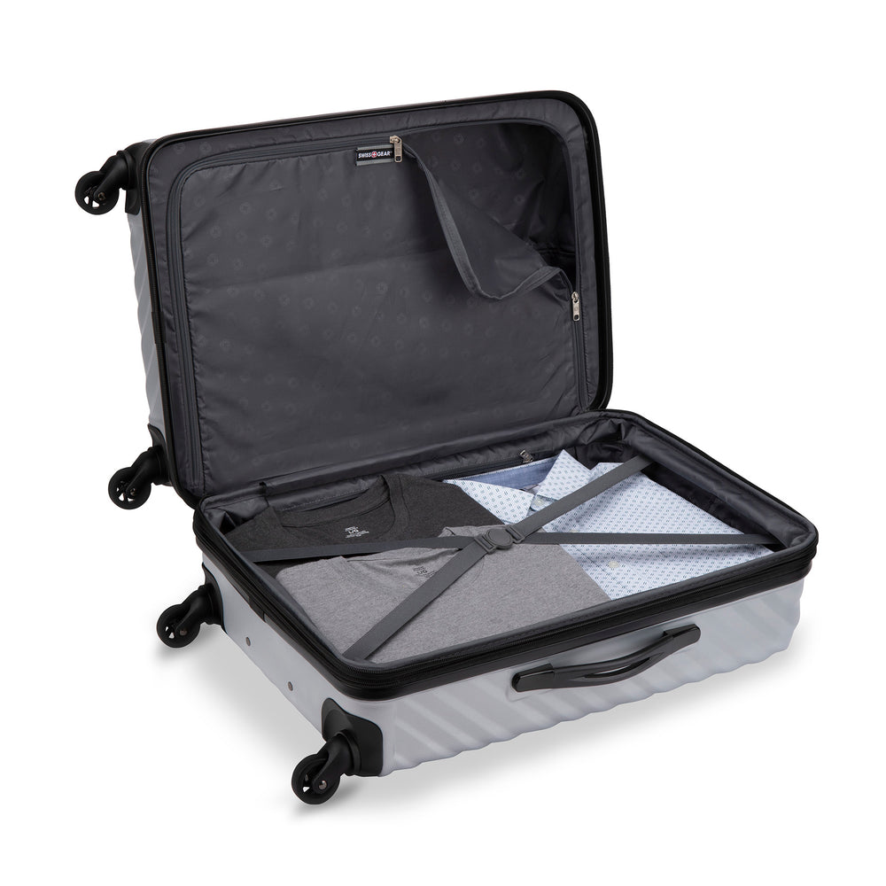 Side view of a grey hardside luggage called MOD designed by Swiss Gear sold at Bentley, showcasing its interior that features compression straps and a divider panel.